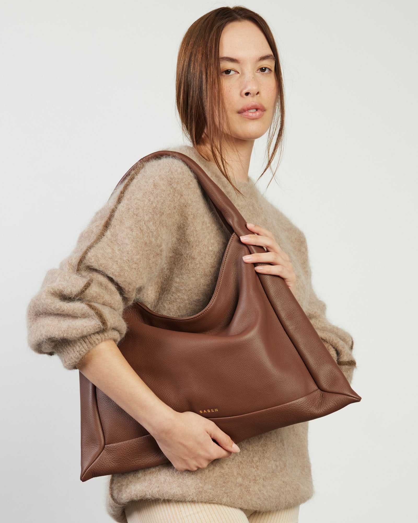Brown leather handbag on a light gray background