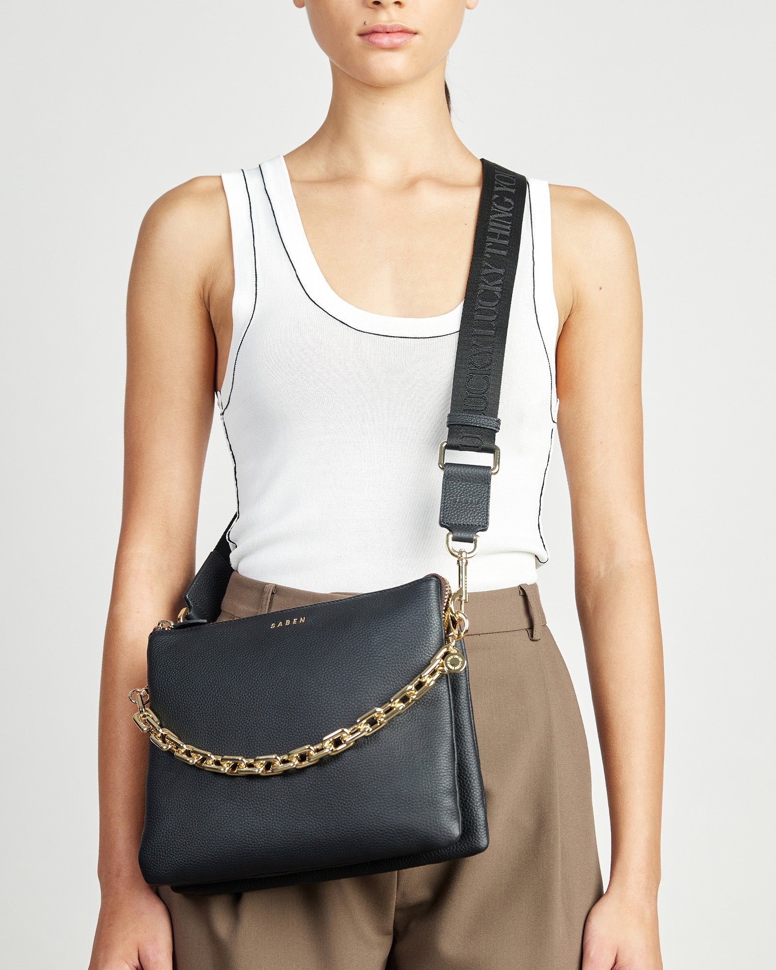 A striped feature strap with black, red, and white colors, with leather trim and gold-plated hardware, fully adjustable.