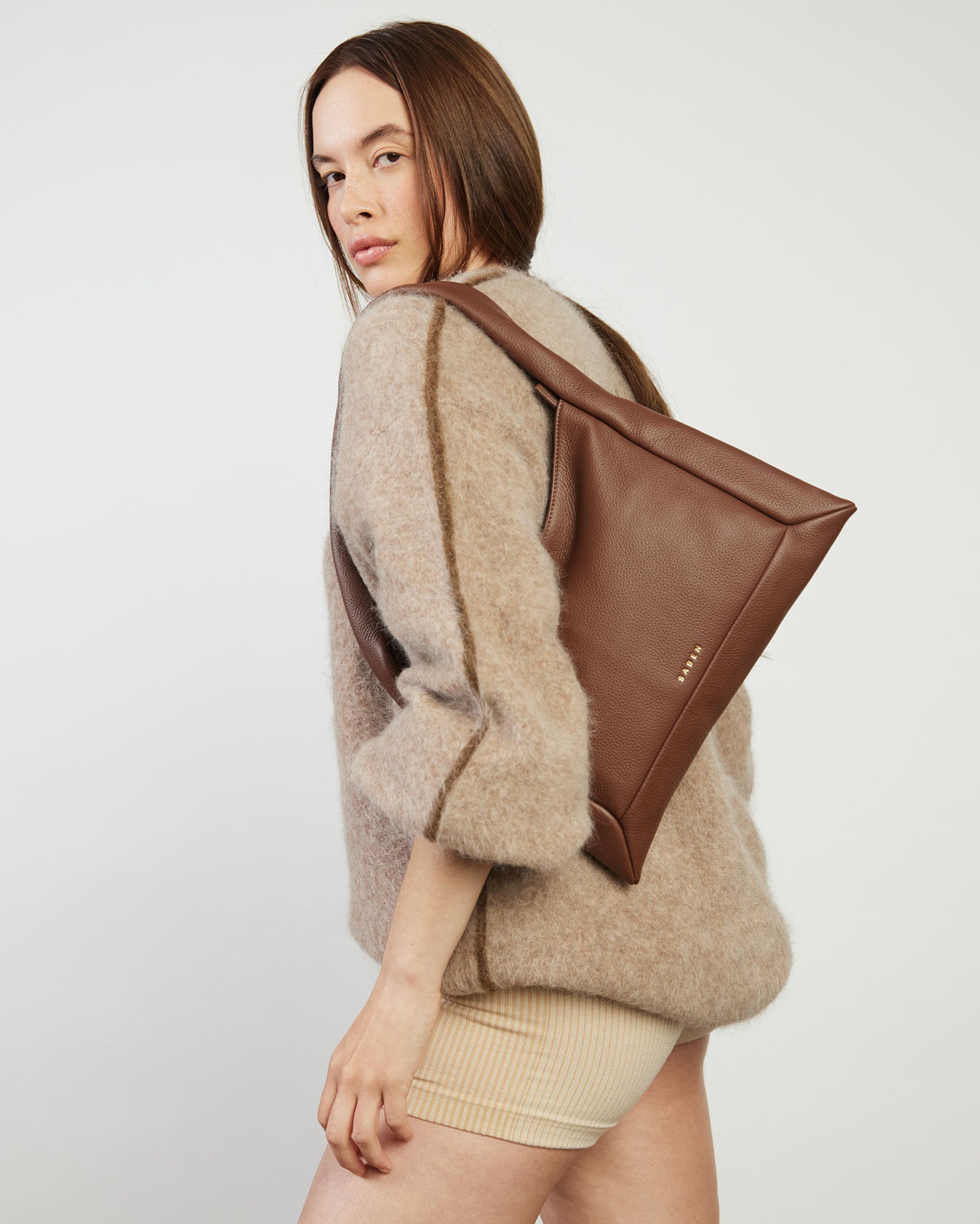 Brown handbag with 'Saks' branding on a light gray background