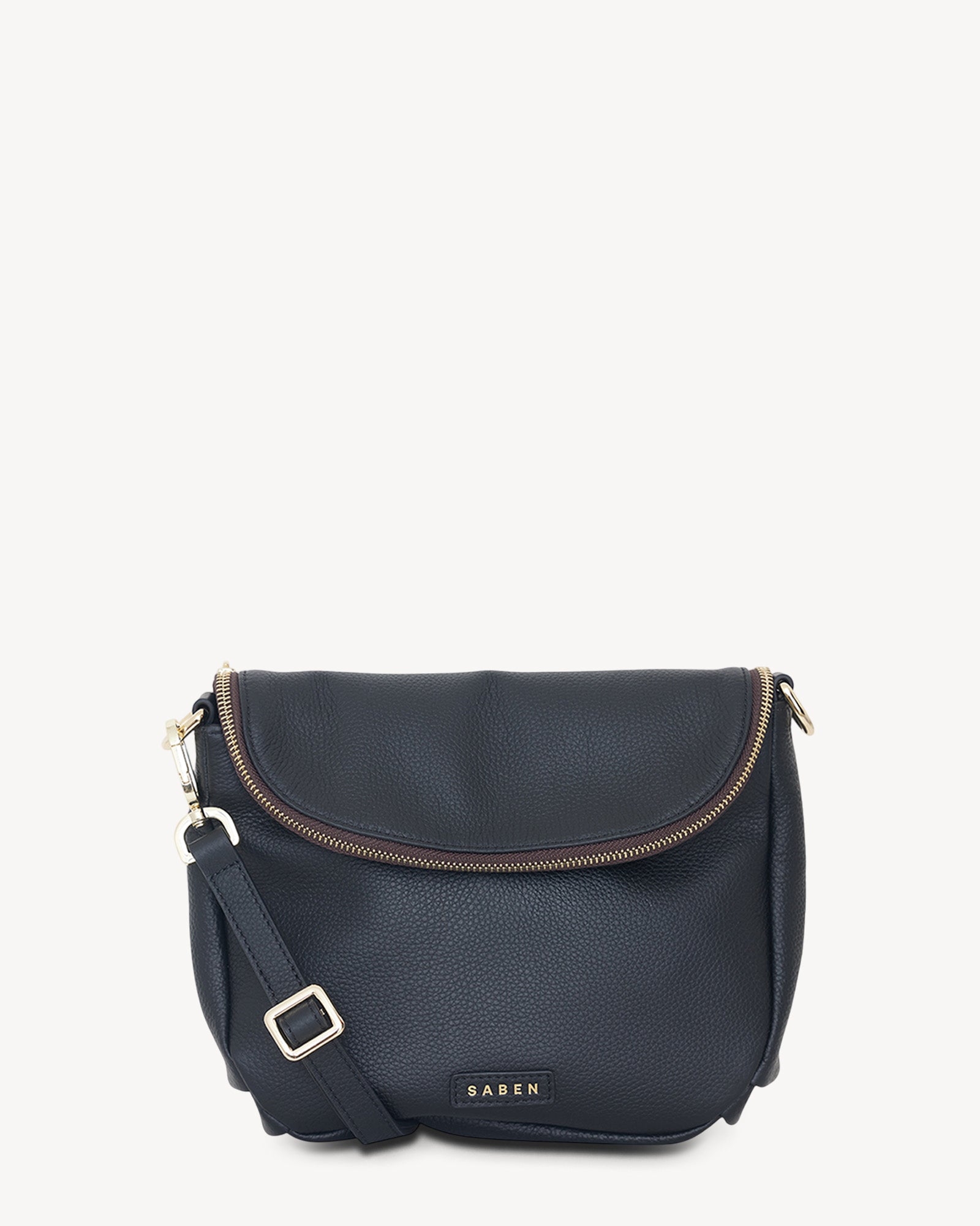 A black leather crossbody bag with a functional zipped flap closure and a detachable strap, featuring gold-plated hardware.