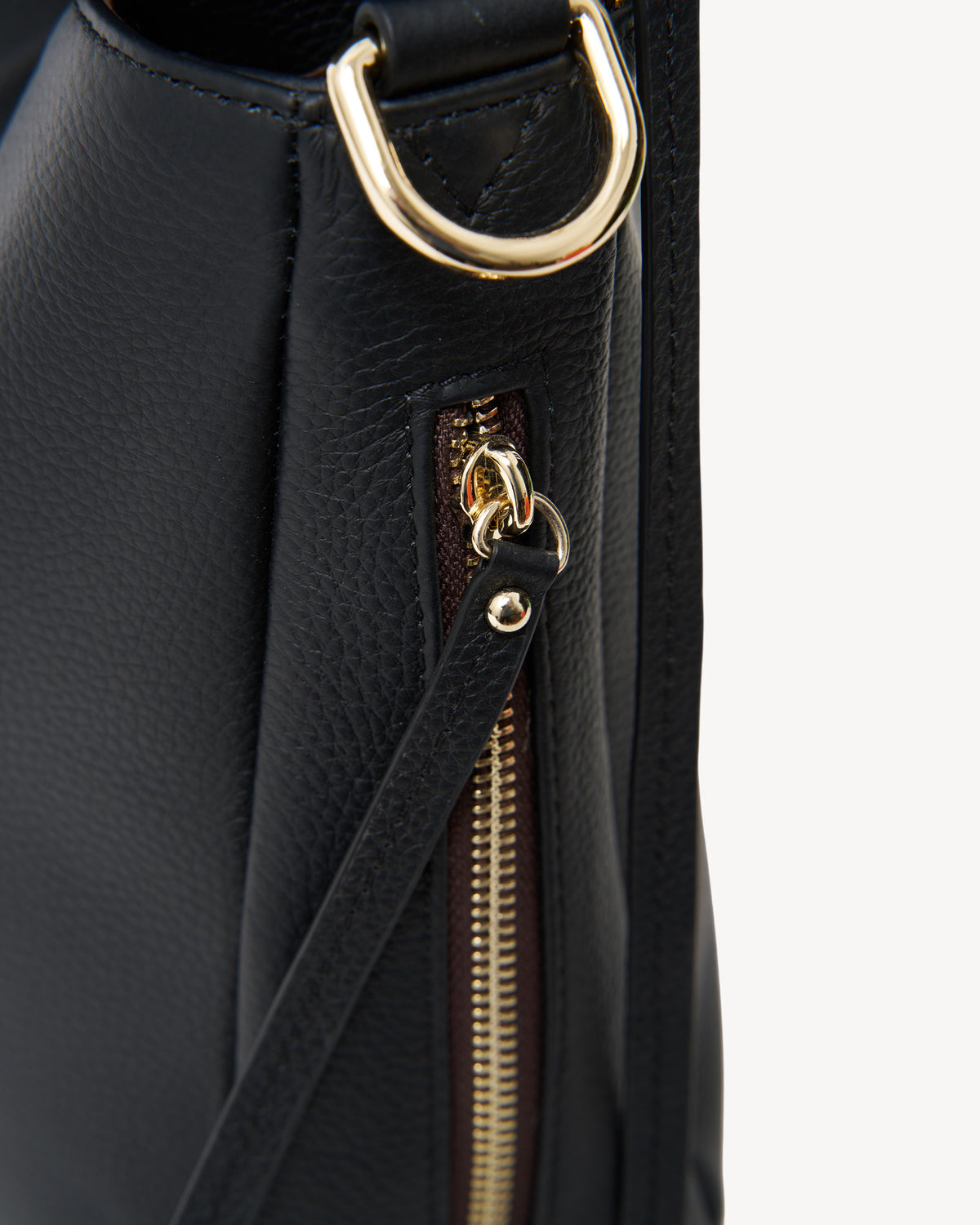 Black leather handbag with gold zipper and hardware on a white background