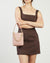 Pink handbag with a gold chain on a white background