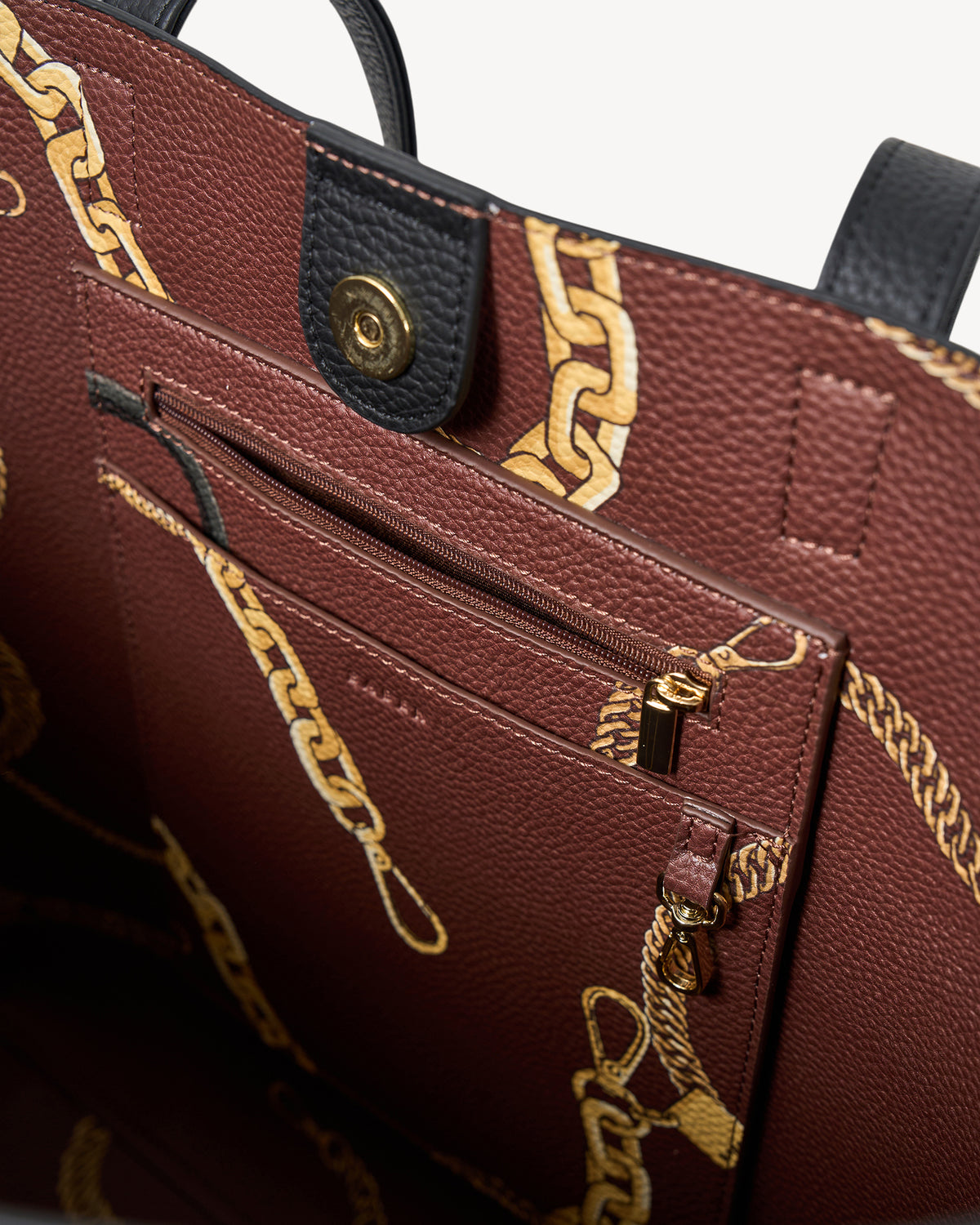Brown leather handbag with gold chain design and visible brand logo.