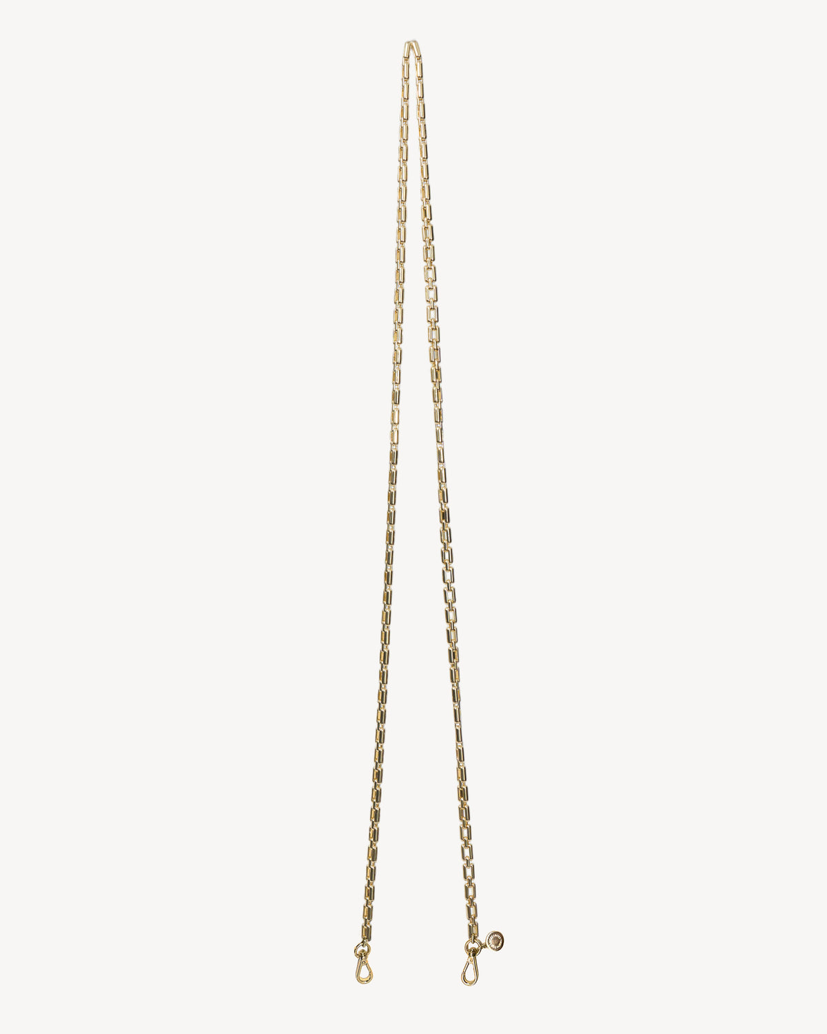 Gold chain necklace on a light beige background