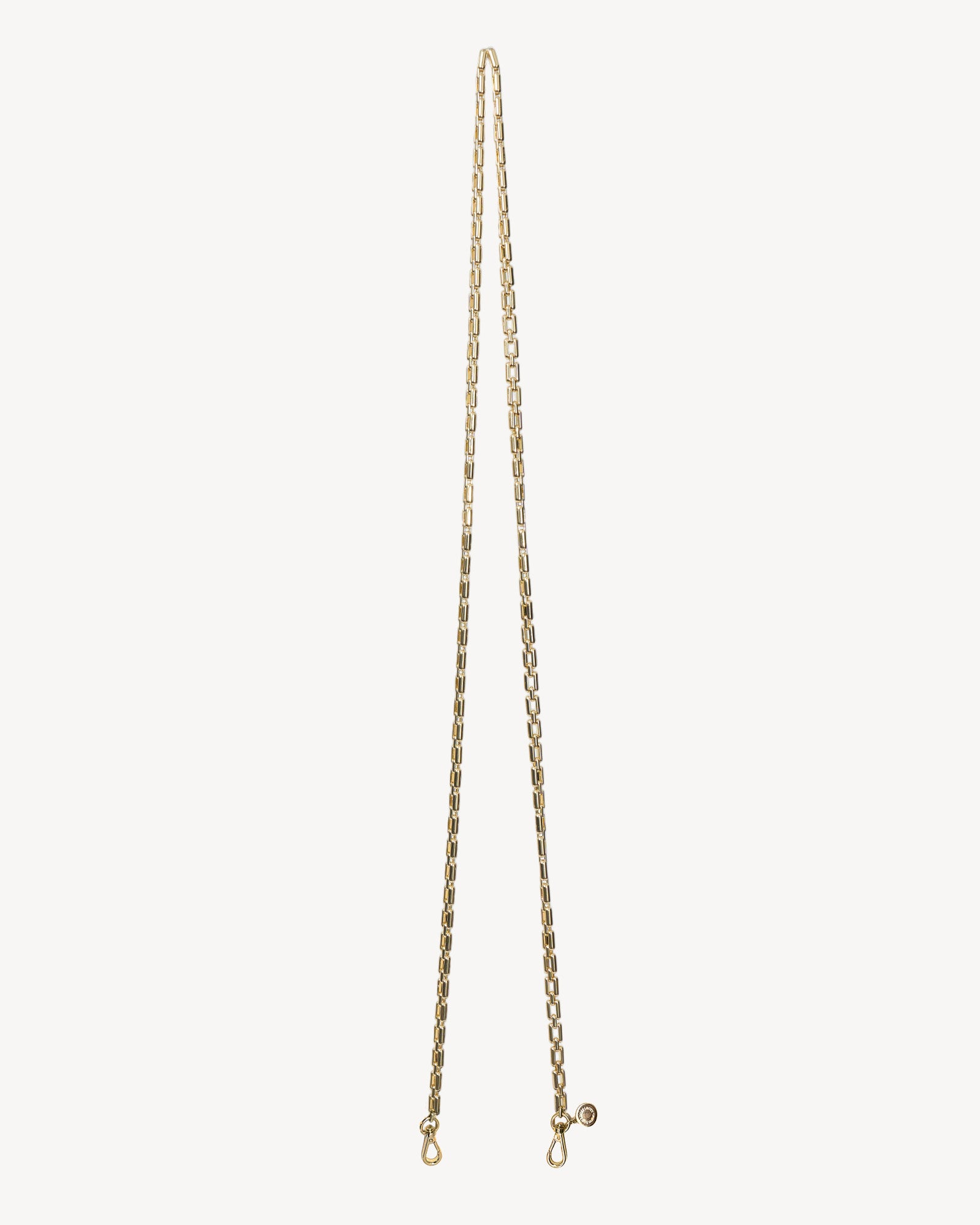 Gold chain necklace on a light beige background