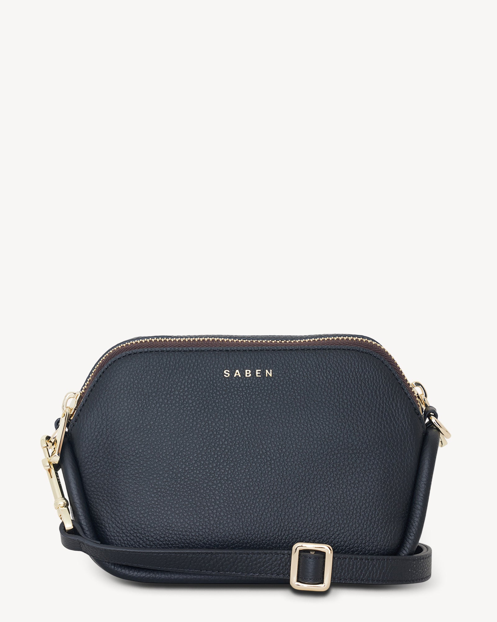 A black pebbled leather crossbody bag with pale gold hardware and a detachable strap, displayed against a white background.