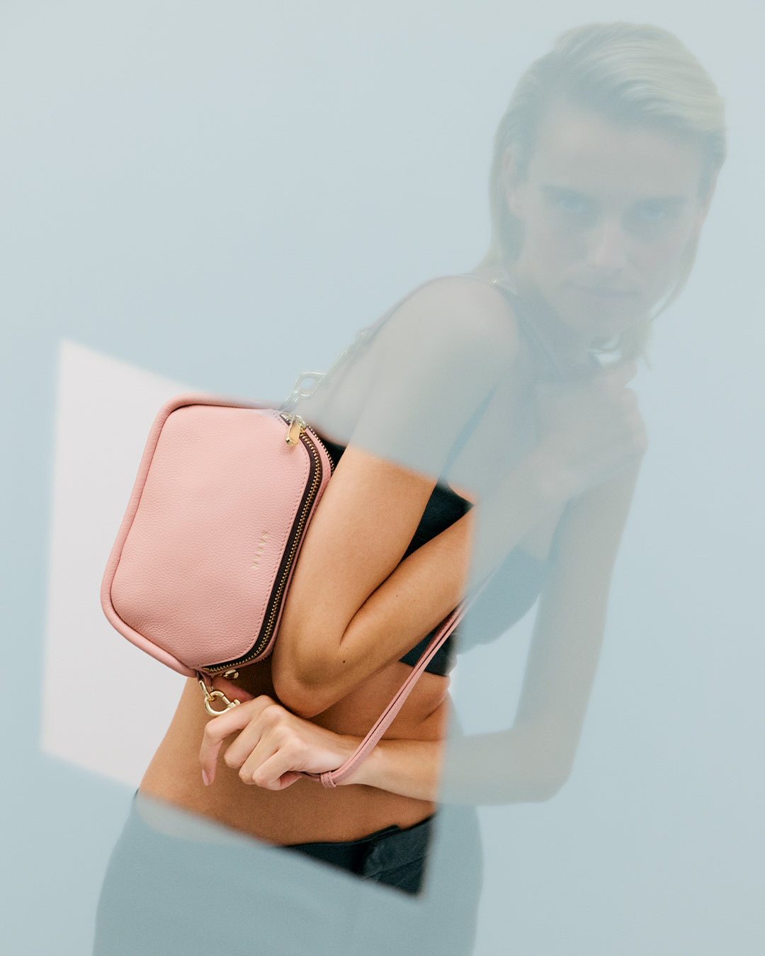 Pink handbag with gold chain on a white background