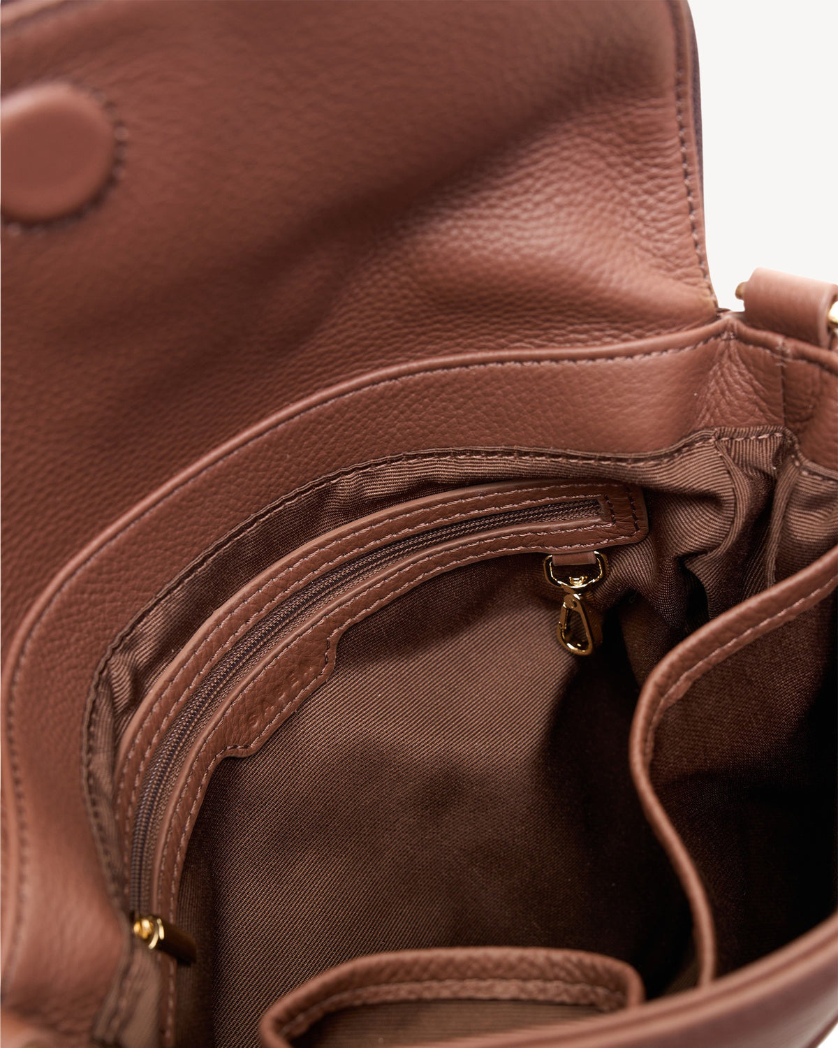 Close-up of a brown leather handbag with a zipper.