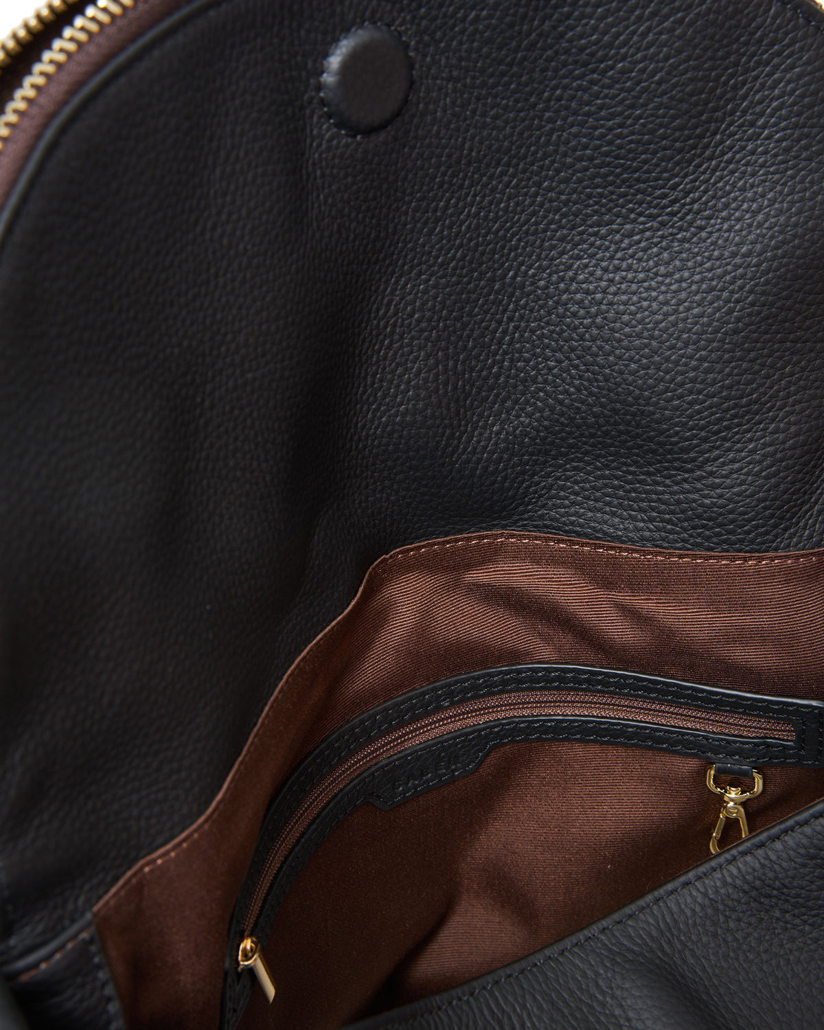 Close-up of a black leather bag with a zipper, showing texture and color contrast.