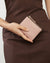 Pink wallet with gold zipper on a white background