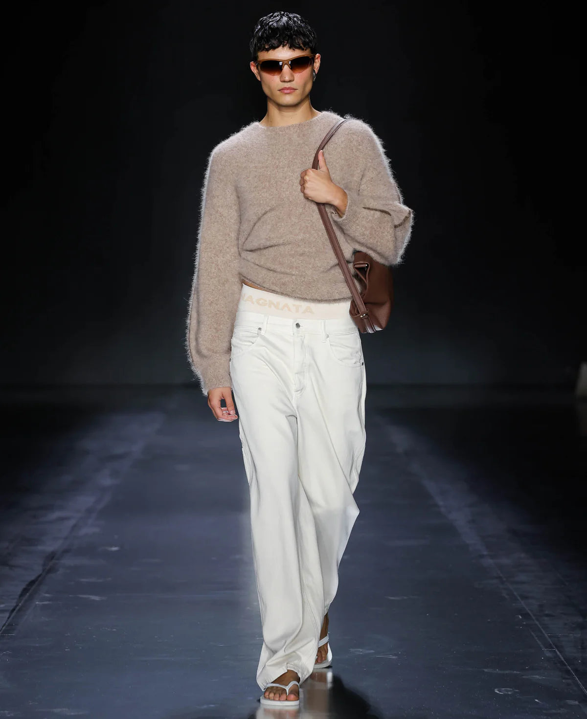 Brown leather handbag with a shoulder strap on a light gray background