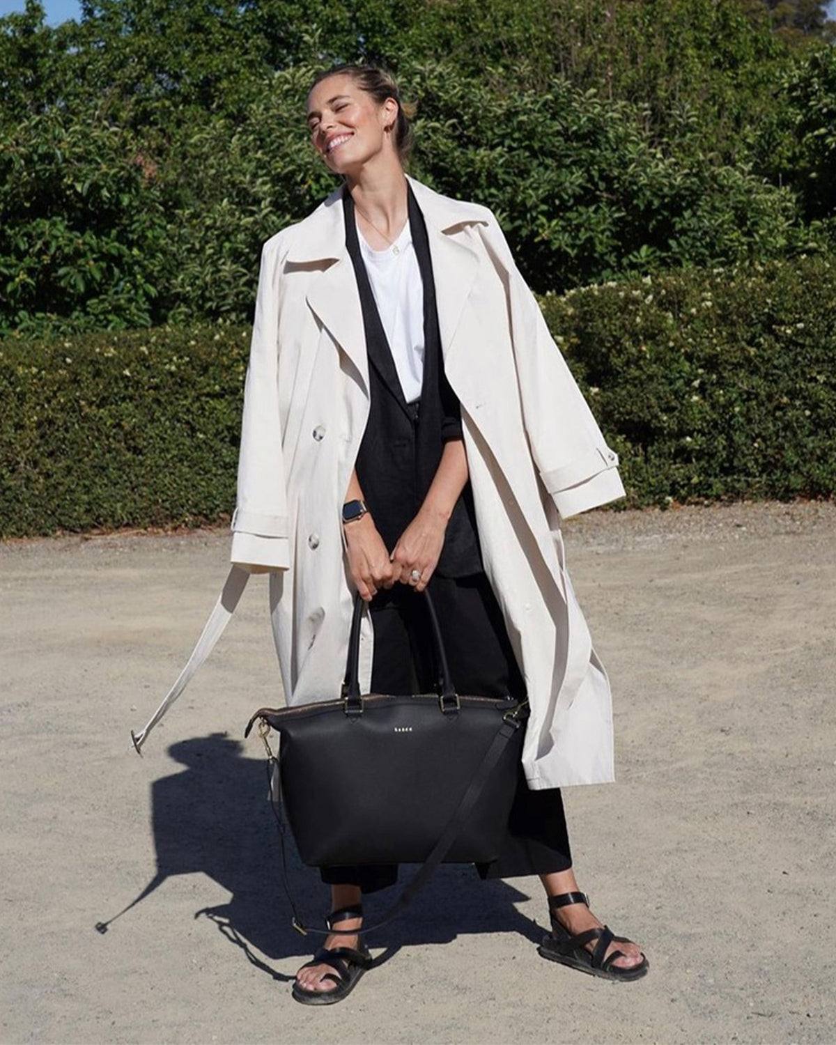 women holding black tote bag