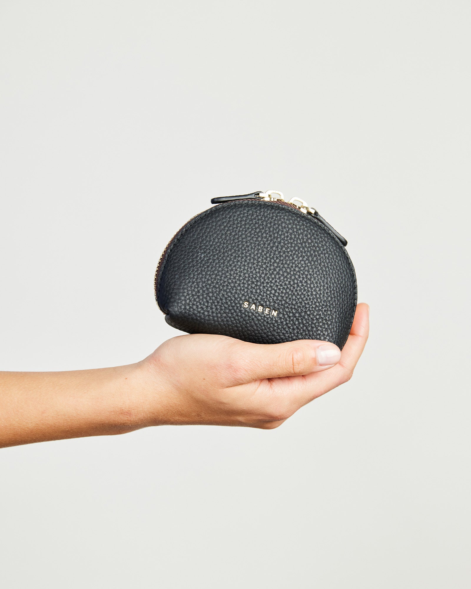 A black leather mini pouch with zip closure, featuring the brand name 'SABEN' embossed on the front.