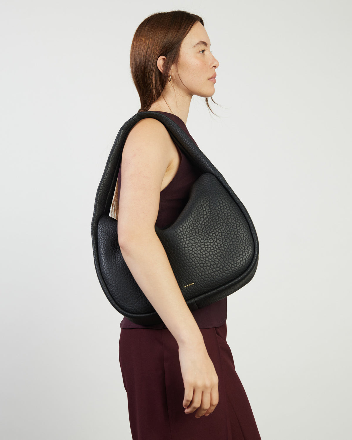 Woman wearing a black backpack against a white background