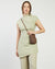 Brown leather crossbody bag with a strap on a white background