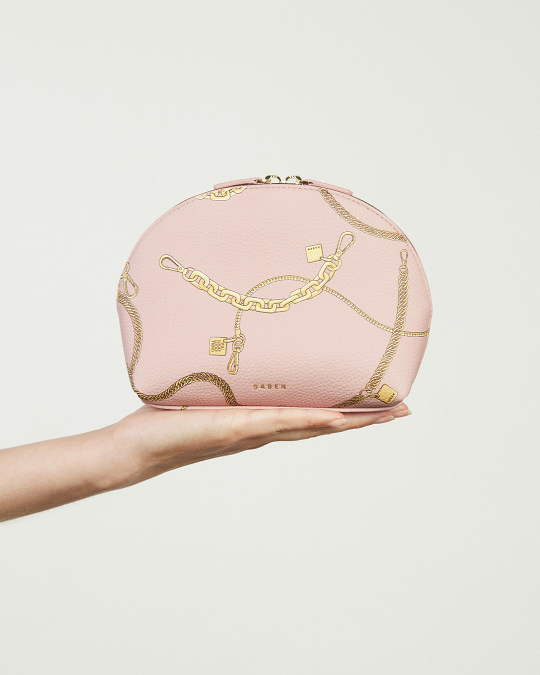 Pink cosmetic bag with gold chain design on a white background